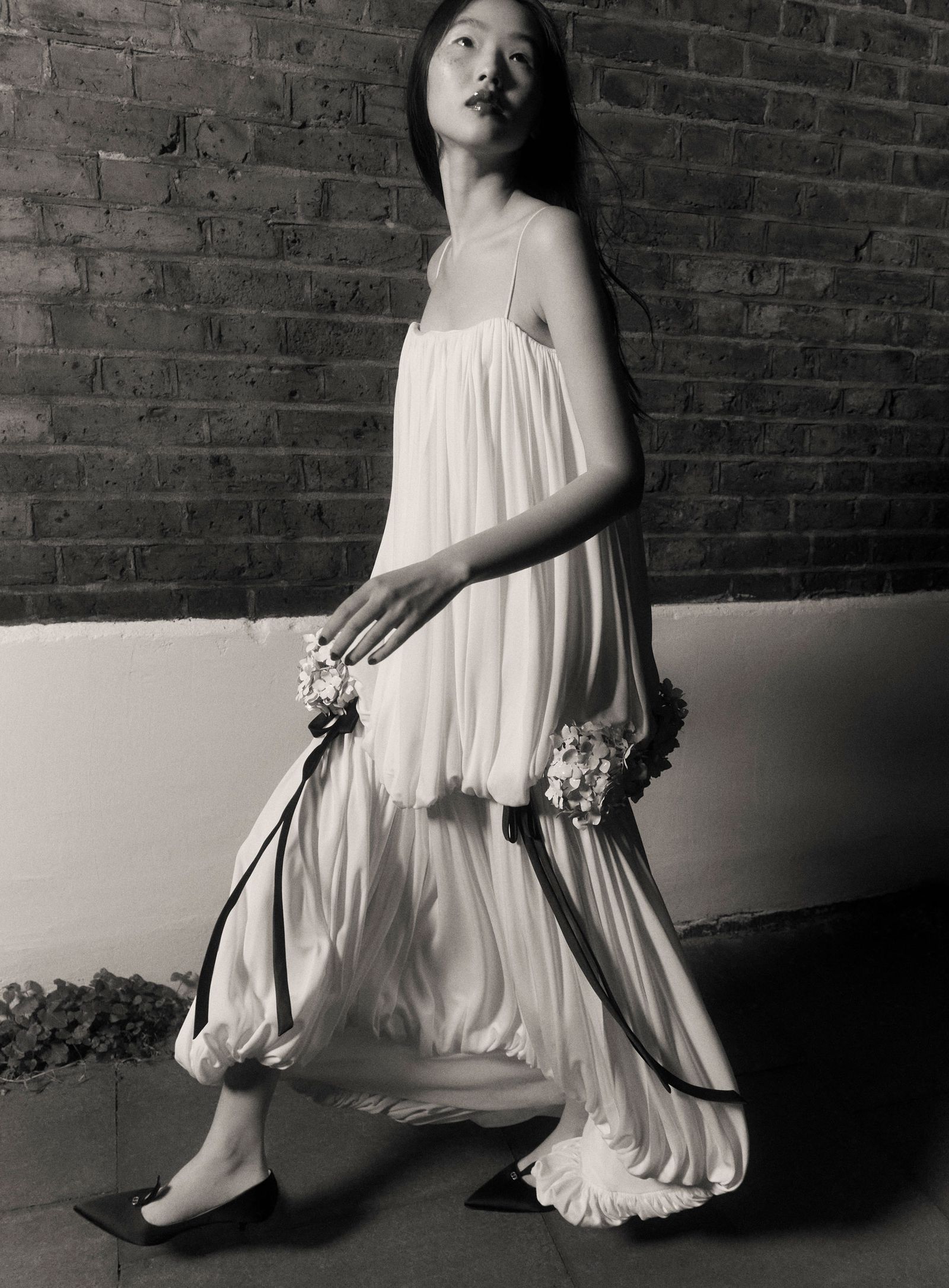 Image may contain Clothing Dress Formal Wear Adult Person Fashion Gown Evening Dress Flower and Flower Arrangement